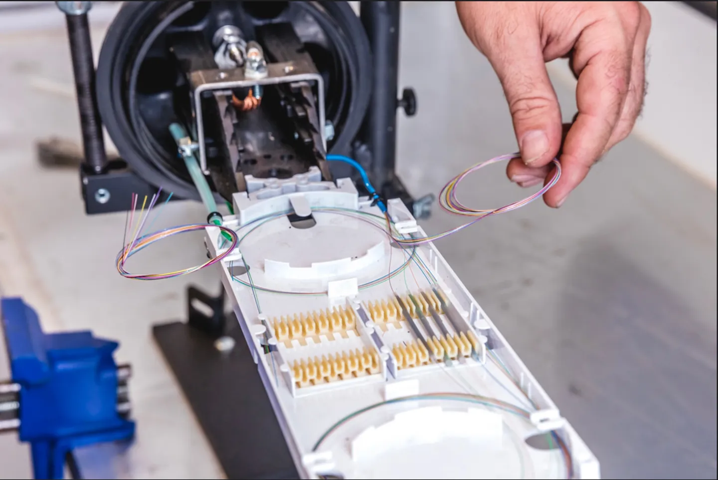 A person is holding wires in front of an electrical device.